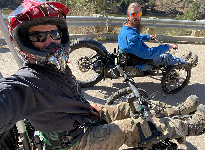 Closeup of two men riding adaptive bikes